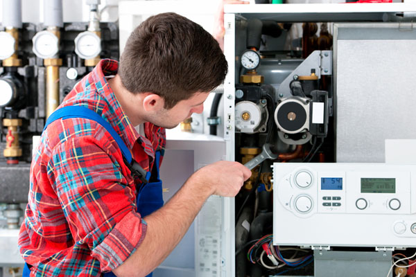HVAC technician inspecting and repairing boiler controls in Apache Junction