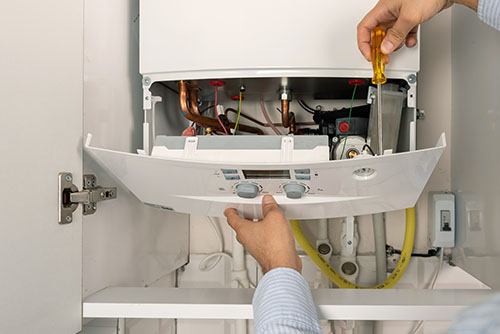 HVAC technician repairing an indoor boiler in Apache Junction