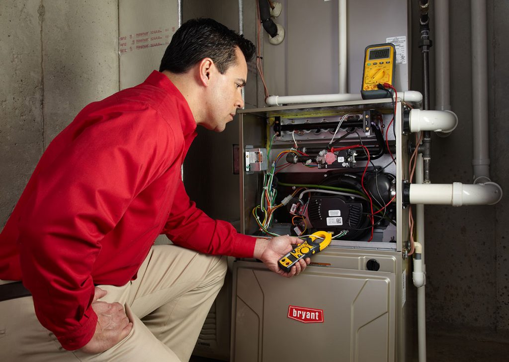 HVAC technician repairing an indoor furnace in Apache Junction