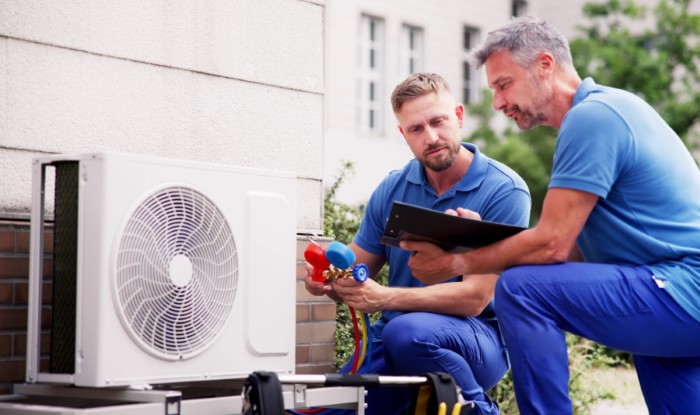 HVAC technicians installing an outdoor air conditioning unit in Apache Junction