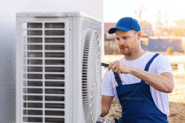 HVAC technician servicing an outdoor air conditioning unit in Apache Junction