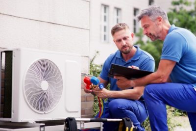 HVAC technicians reviewing an outdoor air conditioning unit in Apache Junction, AZ